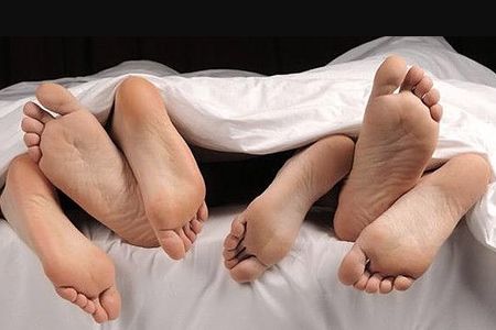 pies de tres personas en la cama